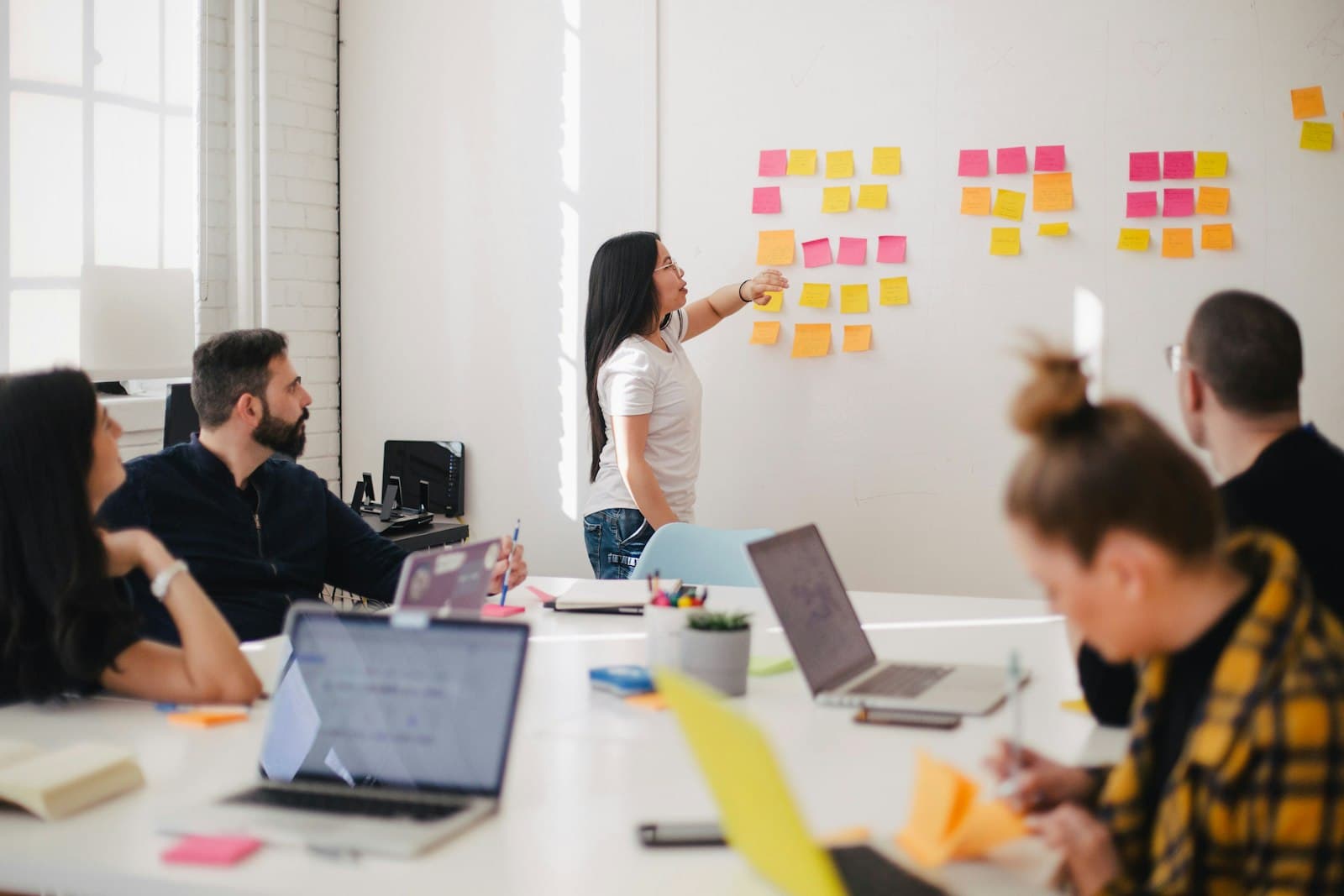 A team planning together in front of a whiteboard covered in sticky notes